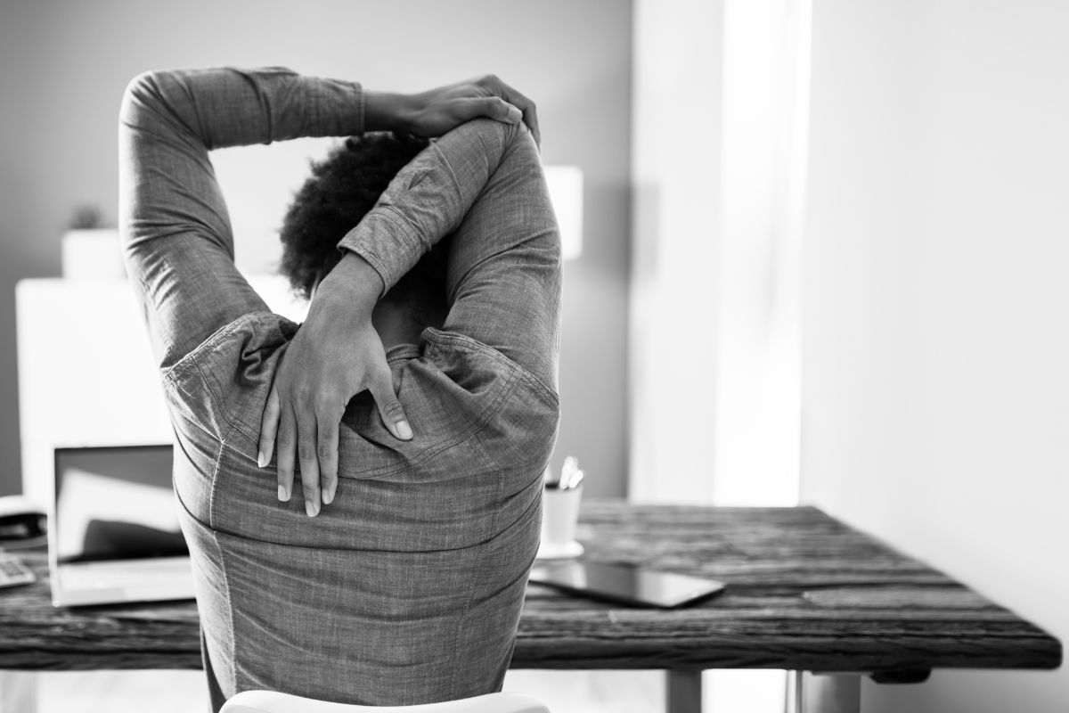 A women stretching at her desk